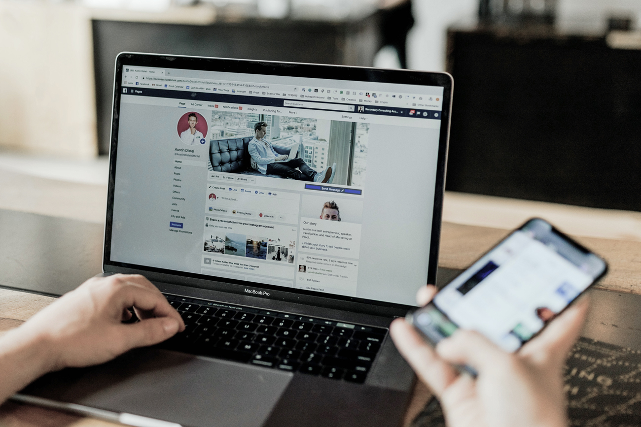 Person using computer and smartphone to communicate via social media